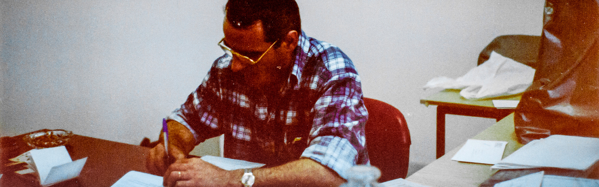 Mario Zinesi firma documenti in ufficio